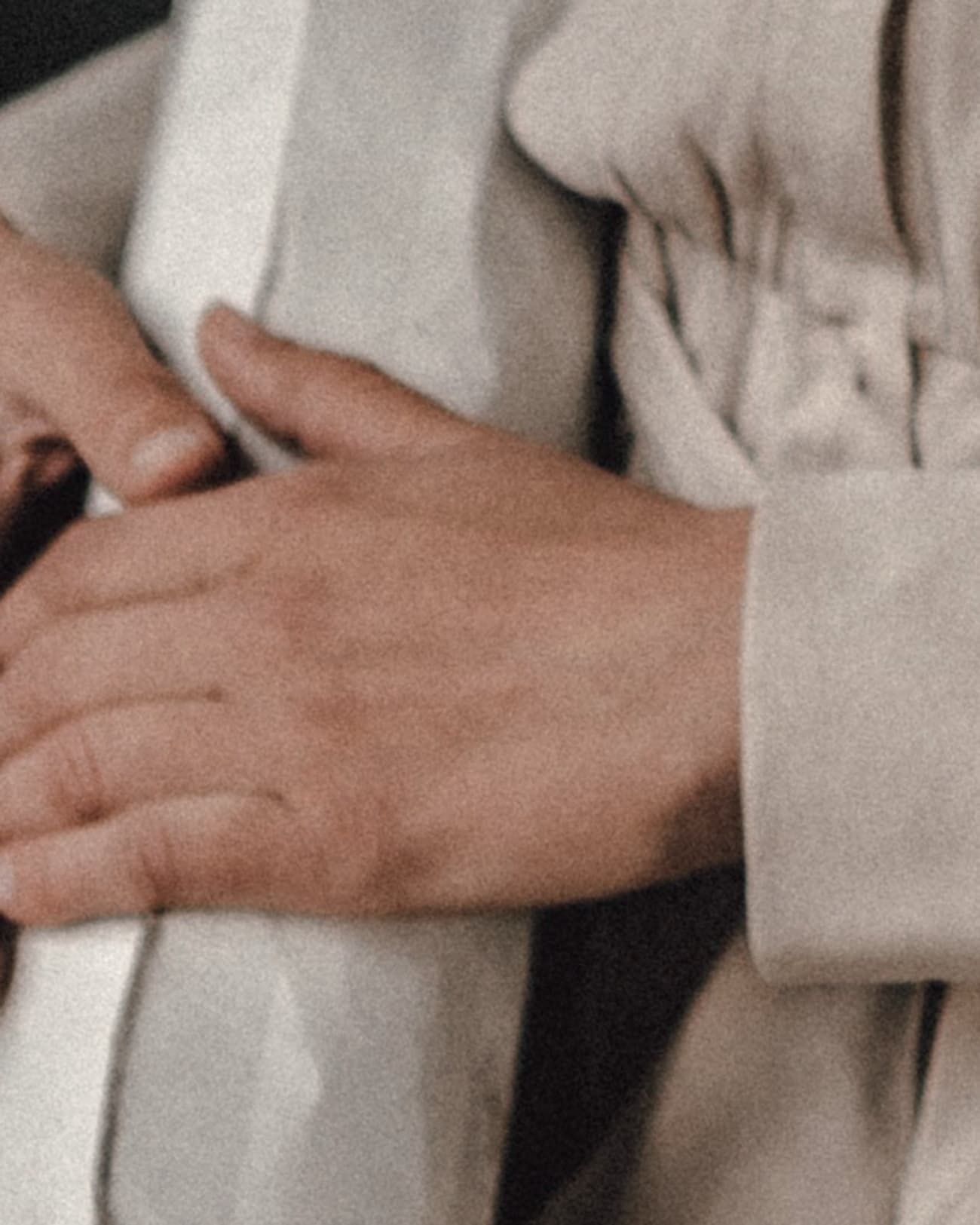 A pair of hands resting, cropped above the wrist